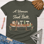 Women's funny woodworking graphic tee shirt for female woodworkers, makers, and DIY builders — Sawdust & Ponytails. Dark gray cotton tee with "A Woman With A Tool Belt" text and a graphic tool belt design.