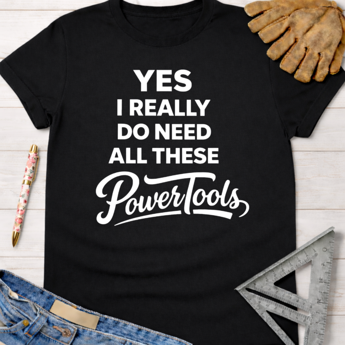 Black cotton tee with "YES I REALLY DO NEED ALL THESE PowerTools" in white text. Women's funny woodworking graphic tee shirt for female woodworkers, makers, and DIY builders — Sawdust & Ponytails