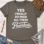 Women's funny woodworking graphic tee shirt for female woodworkers, makers, and DIY builders — Sawdust & Ponytails. Dark gray cotton tee with "YES I REALLY DO NEED ALL THESE PowerTools" in white text.