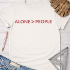 Women's funny woodworking graphic tee shirt for female woodworkers, makers, and DIY builders — Sawdust & Ponytails. Cream t-shirt with "ALONE > PEOPLE" in pink text.