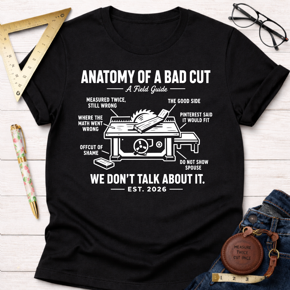 Women's funny woodworking graphic tee shirt for female woodworkers, makers, and DIY builders — Sawdust & Ponytails. Black cotton tee with "Anatomy of a Bad Cut" table saw diagram.