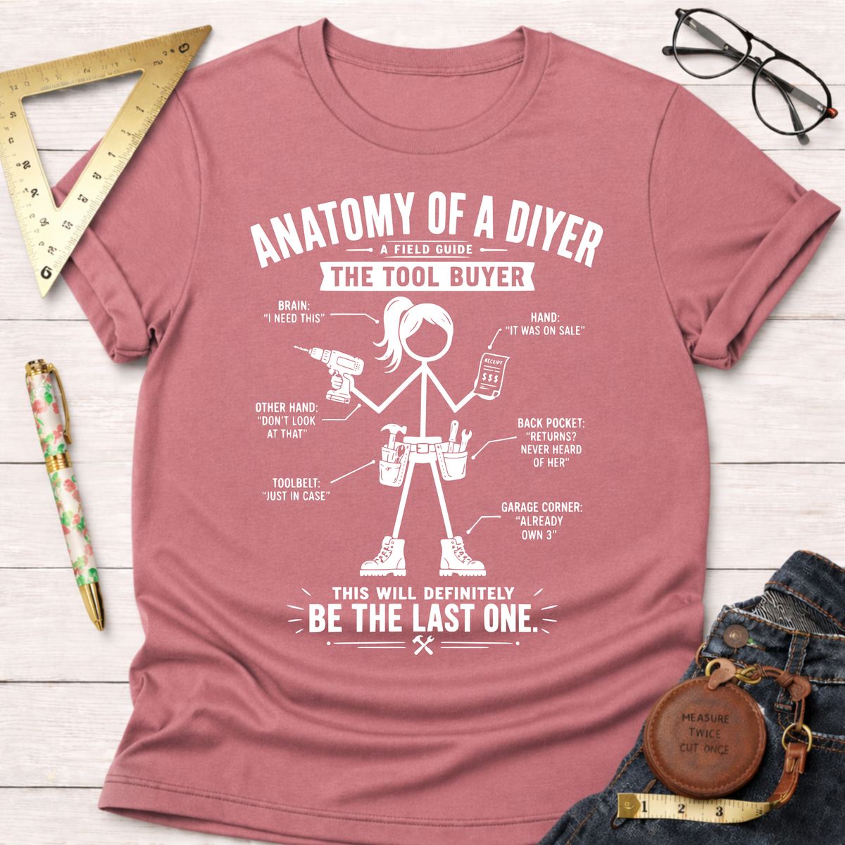 Women's funny woodworking graphic tee shirt for female woodworkers, makers, and DIY builders — Sawdust & Ponytails. Mauve short-sleeve t-shirt with "Anatomy of a DIYer: The Tool Buyer" graphic.