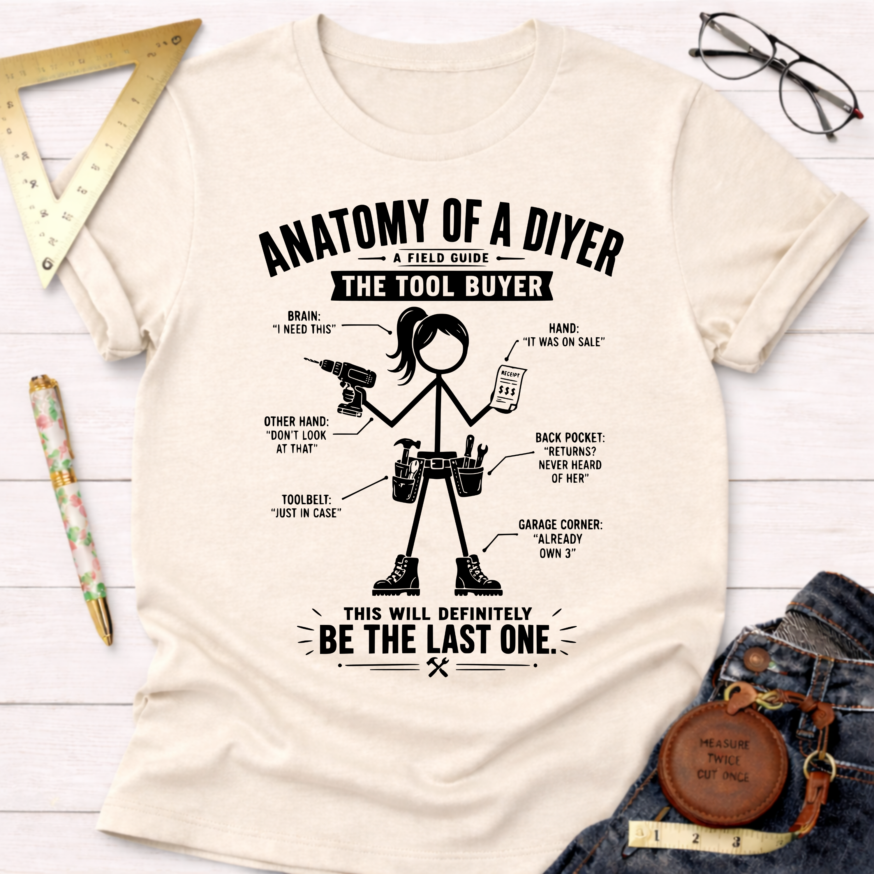Women's funny woodworking graphic tee shirt for female woodworkers, makers, and DIY builders — Sawdust & Ponytails. Cream t-shirt with "Anatomy of a DIYer: The Tool Buyer" graphic.