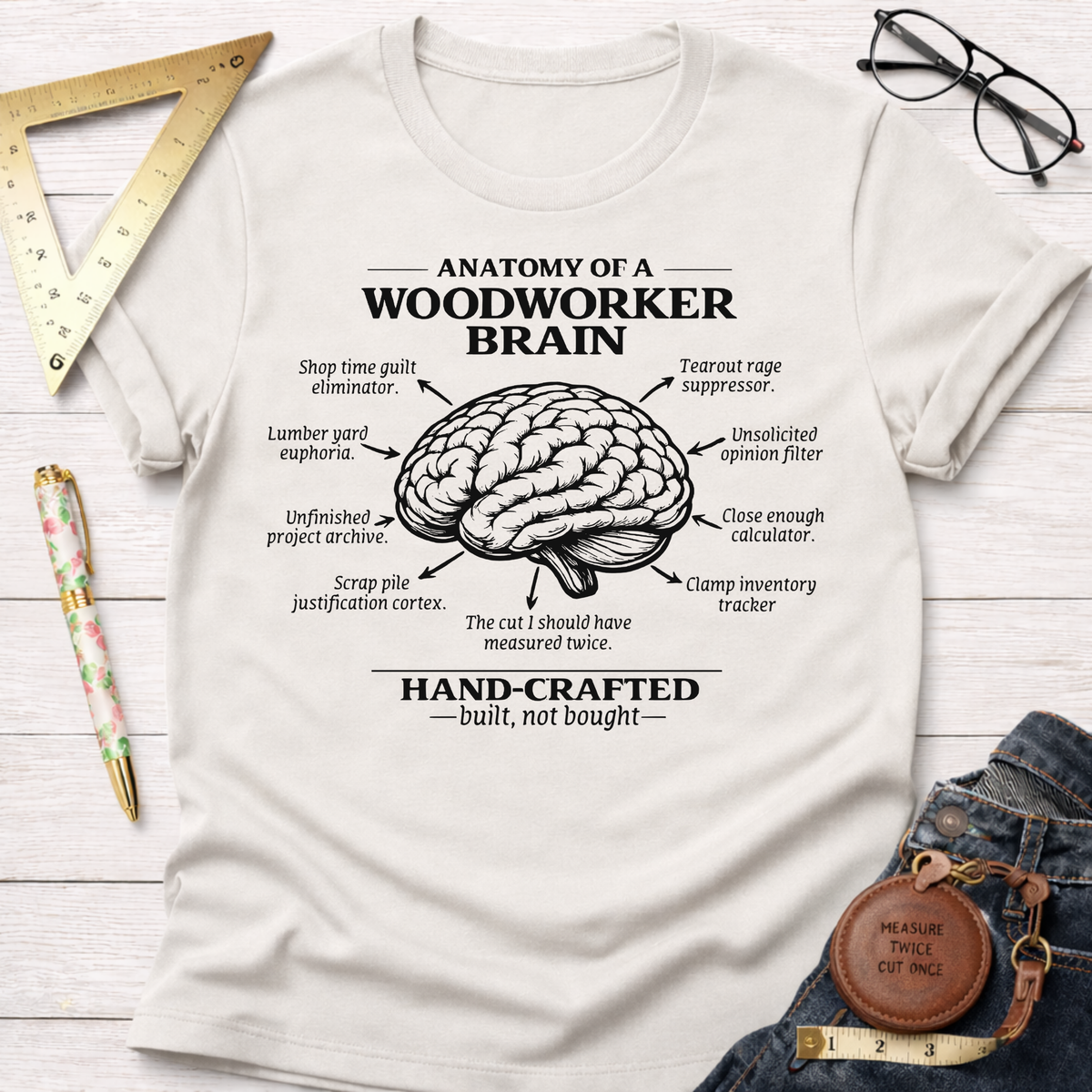 Women's funny woodworking graphic tee shirt for female woodworkers, makers, and DIY builders — Sawdust & Ponytails. Cream t-shirt with "Anatomy of a Woodworker Brain" graphic.