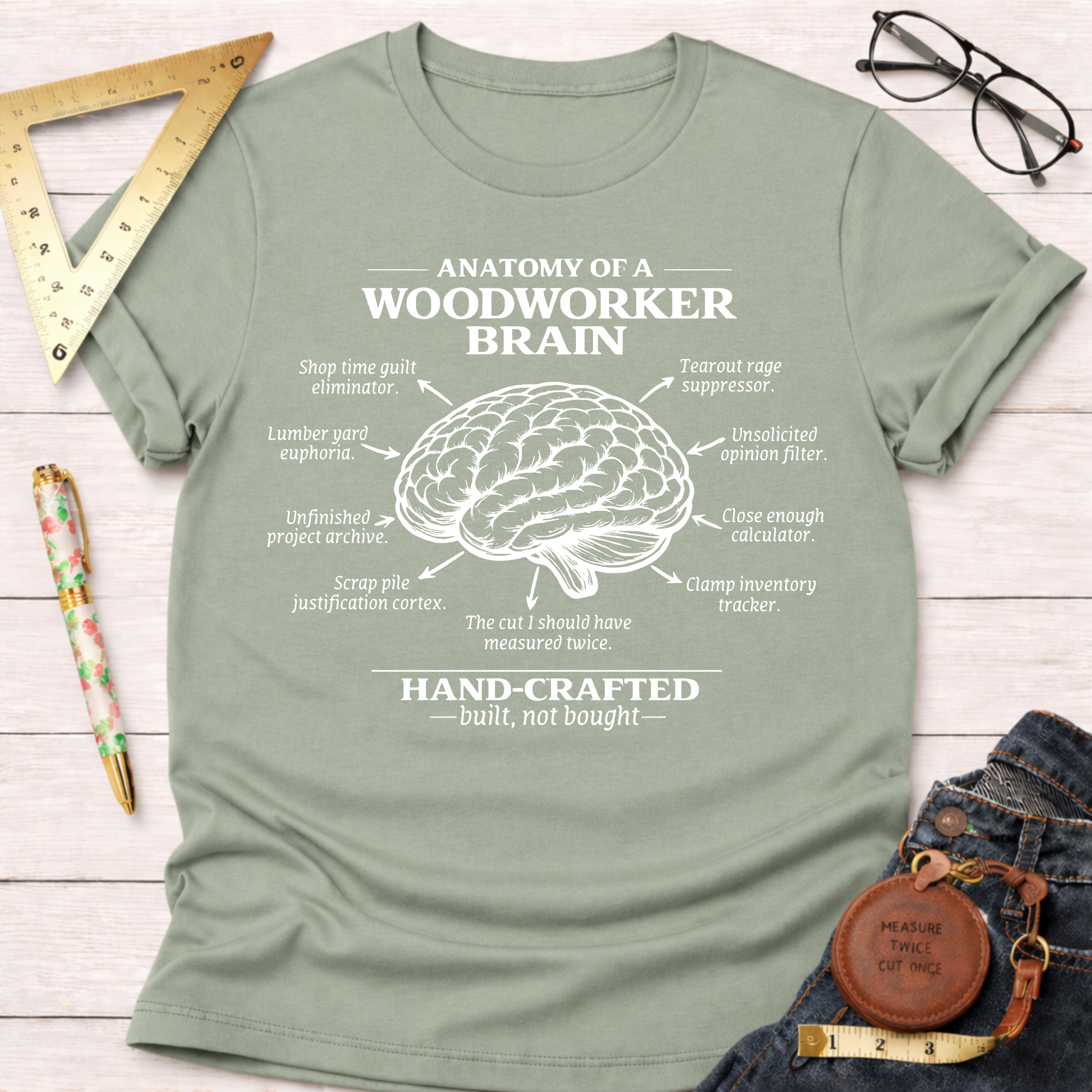 Women's funny woodworking graphic tee shirt for female woodworkers, makers, and DIY builders — Sawdust & Ponytails. Light green crew neck t-shirt with "Anatomy of a Woodworker Brain" graphic.