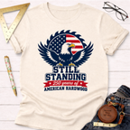 Cream cotton t-shirt with a patriotic bald eagle and saw blade graphic, "Still Standing" text, and "250 Years of American Hardwood.