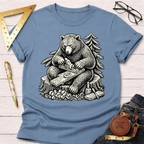 Women's funny woodworking graphic tee shirt for female woodworkers, makers, and DIY builders — Sawdust & Ponytails. Light blue cotton tee with a black and white graphic of a bear hand planing wood on a tree stump.