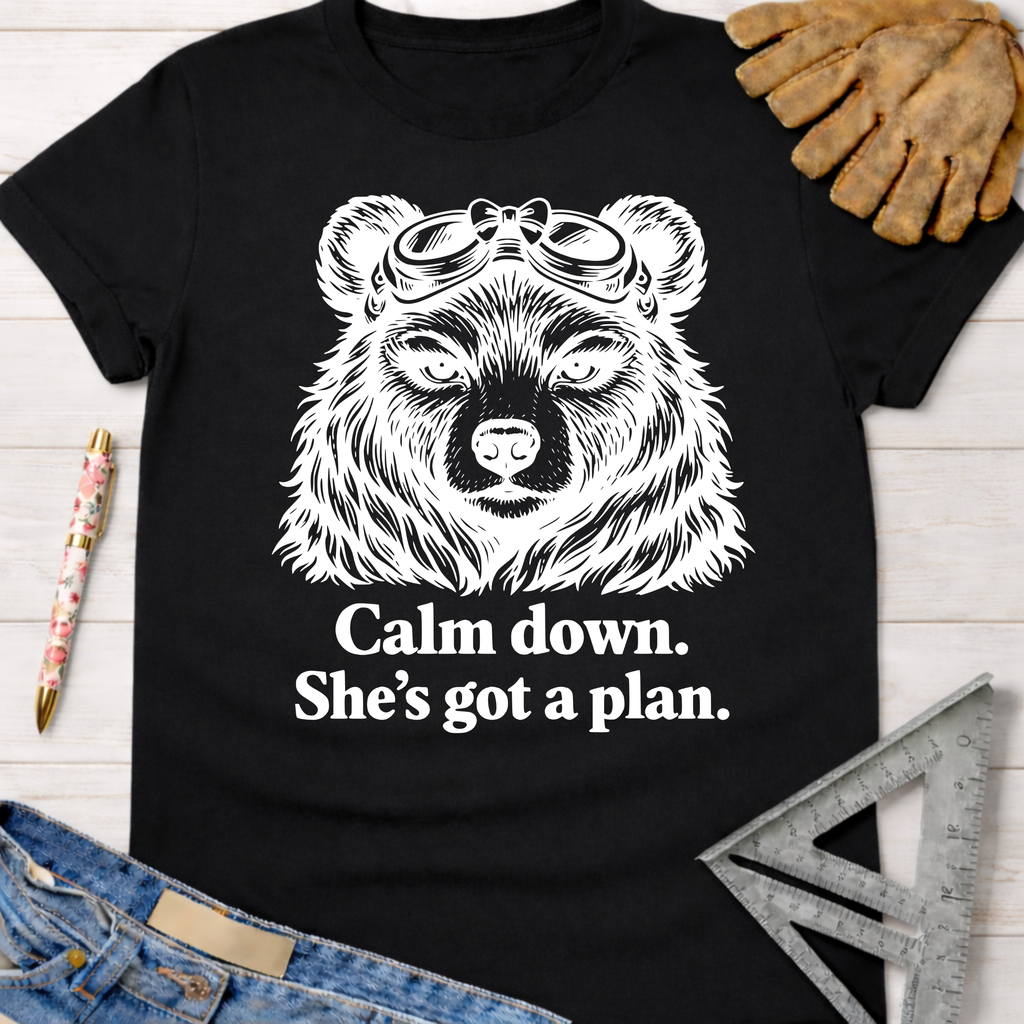 Black cotton women's funny woodworking graphic tee with a bear in goggles and "Calm down. She's got a plan." text.