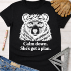 Black cotton women's funny woodworking graphic tee with a bear in goggles and "Calm down. She's got a plan." text.