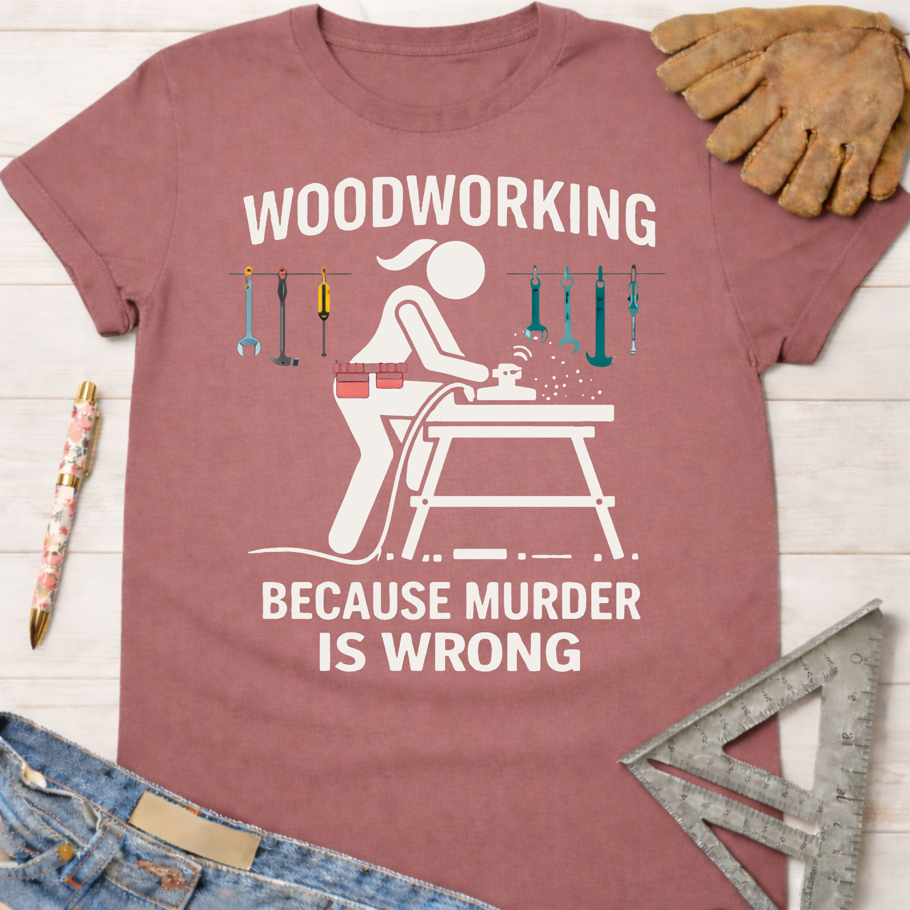 Women's funny woodworking graphic tee shirt for female woodworkers, makers, and DIY builders — Sawdust & Ponytails. Mauve short-sleeve tee with "Woodworking Because Murder is Wrong" graphic.