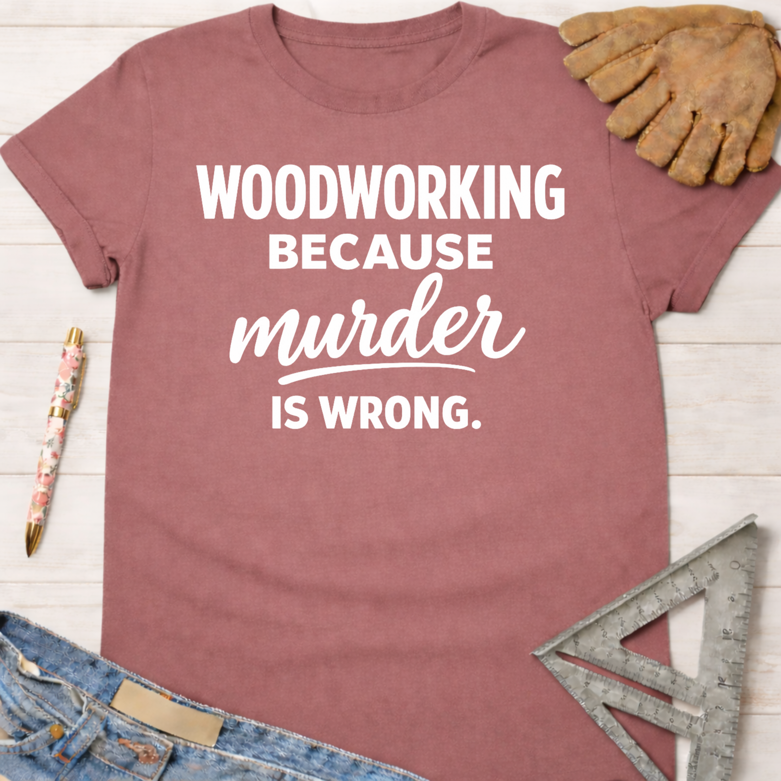 Women's funny woodworking graphic tee shirt for female woodworkers, makers, and DIY builders — Sawdust & Ponytails. Mauve short-sleeve t-shirt with "Woodworking Because Murder Is Wrong" in white text.