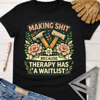 Women's funny woodworking graphic tee shirt for female woodworkers, makers, and DIY builders — Sawdust & Ponytails. Black cotton tee with "Making Shit Because Therapy Has A Waitlist" graphic featuring hammers and pink flowers.