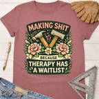 Women's funny woodworking graphic tee shirt for female woodworkers, makers, and DIY builders — Sawdust & Ponytails. Mauve cotton tee with "Making Shit Because Therapy Has A Waitlist" graphic featuring hammers and flowers.