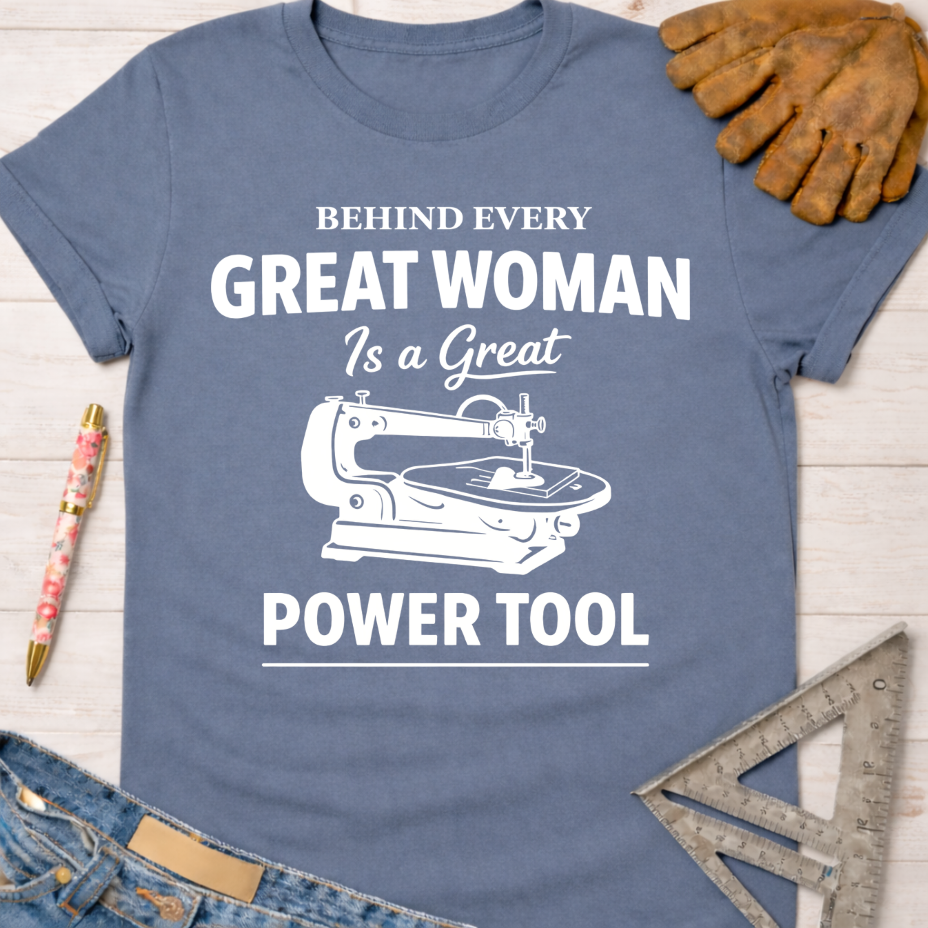 Women's funny woodworking graphic tee shirt for female woodworkers, makers, and DIY builders — Sawdust & Ponytails. Blue cotton tee with "Behind Every Great Woman Is a Great Power Tool" graphic.