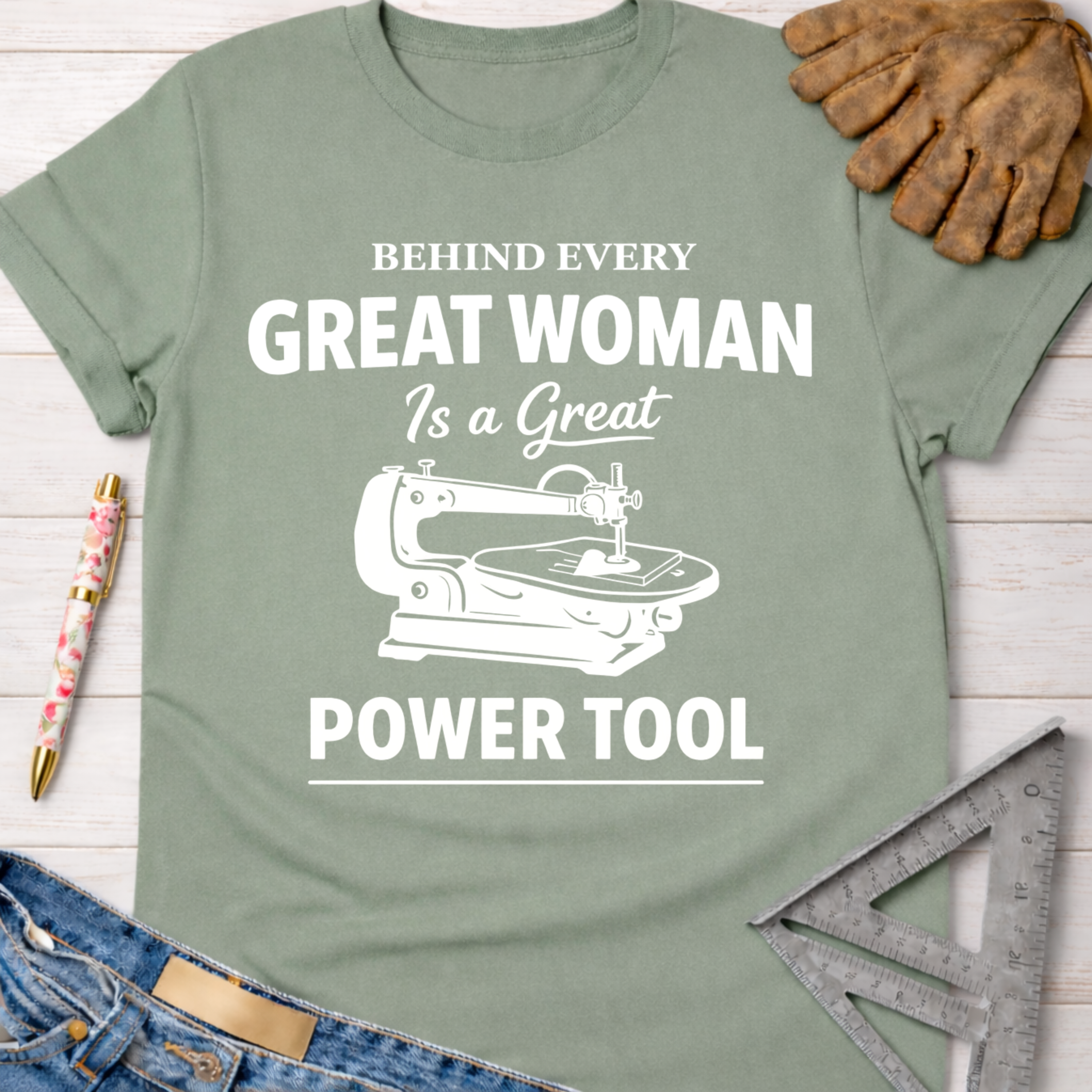 Sage green cotton tee with "Behind Every Great Woman Is a Great Power Tool" graphic. Women's funny woodworking graphic tee shirt for female woodworkers, makers, and DIY builders — Sawdust & Ponytails