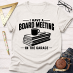 Off-white "Board Meeting In The Garage" t-shirt with wood planks, coffee mug, and pencil graphic.