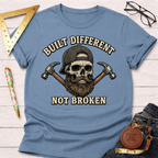 Light blue "Built Different Not Broken" t-shirt with a skull wearing a cap and beard, flanked by hammers.