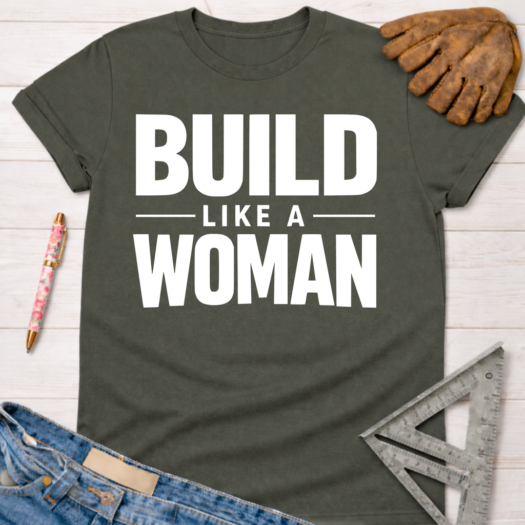 Women's funny woodworking graphic tee shirt for female woodworkers, makers, and DIY builders — Sawdust & Ponytails. Dark gray cotton tee with "BUILD LIKE A WOMAN" in white text.