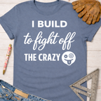 Women's funny woodworking graphic tee shirt for female woodworkers, makers, and DIY builders — Sawdust & Ponytails. Blue cotton tee with "I Build to fight off THE CRAZY" text.