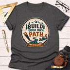 Charcoal gray "Build Your Own Path" t-shirt with a wood slice graphic, trees, saw, and plane.
