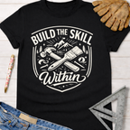 Women's funny woodworking graphic tee shirt for female woodworkers, makers, and DIY builders — Sawdust & Ponytails. Black cotton tee with "Build The Skill Within" graphic featuring hammer, paintbrush, and mountains.