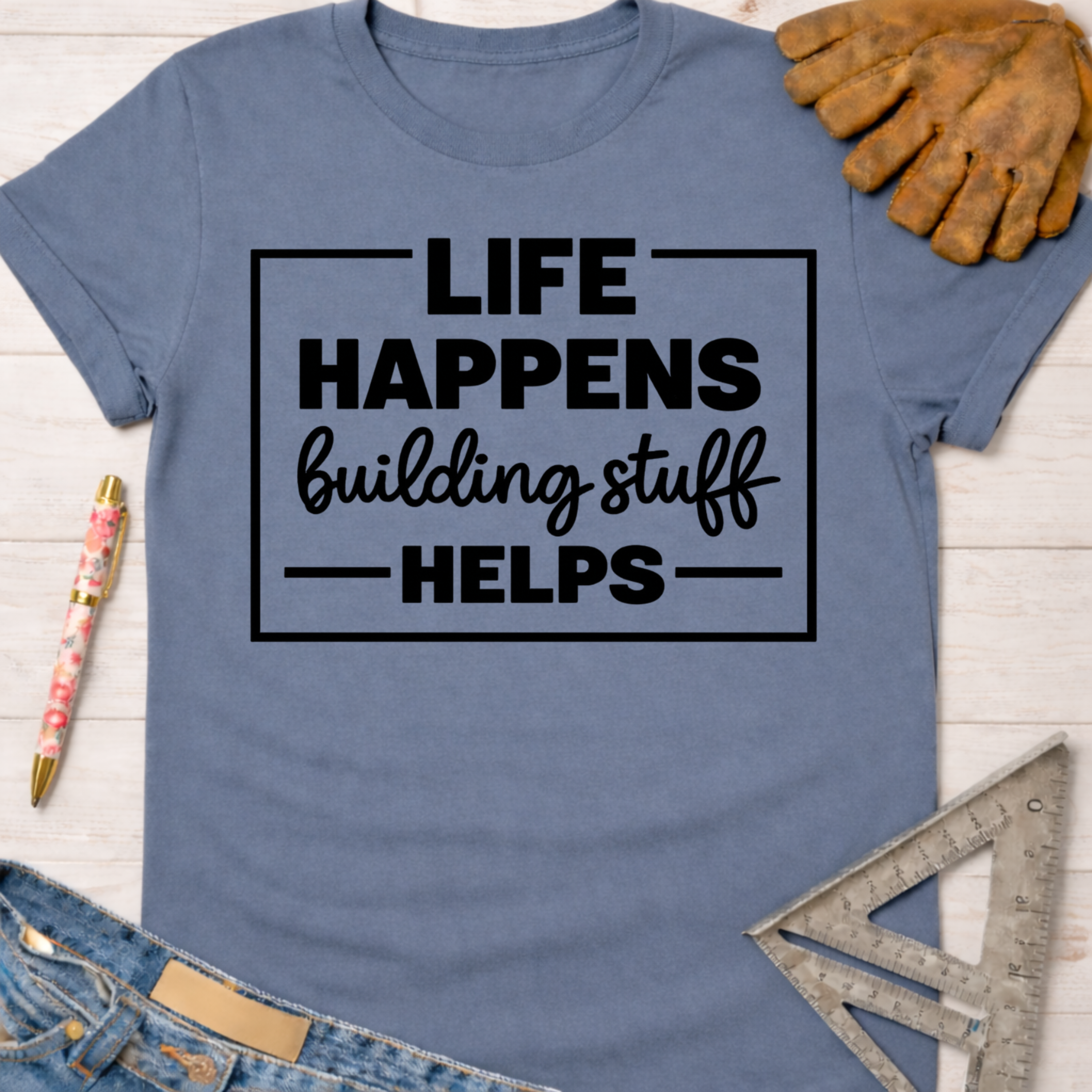 Women's funny woodworking graphic tee shirt for female woodworkers, makers, and DIY builders — Sawdust & Ponytails. Blue short-sleeve tee with "Life Happens Building Stuff Helps" text.
