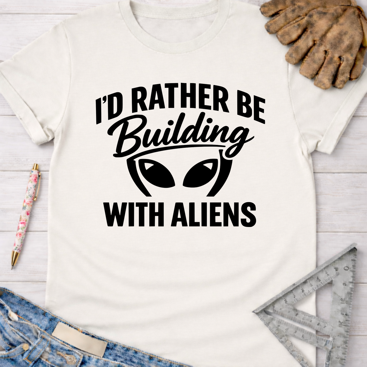 Women's funny woodworking graphic tee shirt for female woodworkers, makers, and DIY builders — Sawdust & Ponytails. White cotton tee with "I'd Rather Be Building With Aliens" graphic.