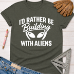 Women's funny woodworking graphic tee shirt for female woodworkers, makers, and DIY builders — Sawdust & Ponytails. Dark gray t-shirt with "I'd Rather Be Building With Aliens" white graphic.