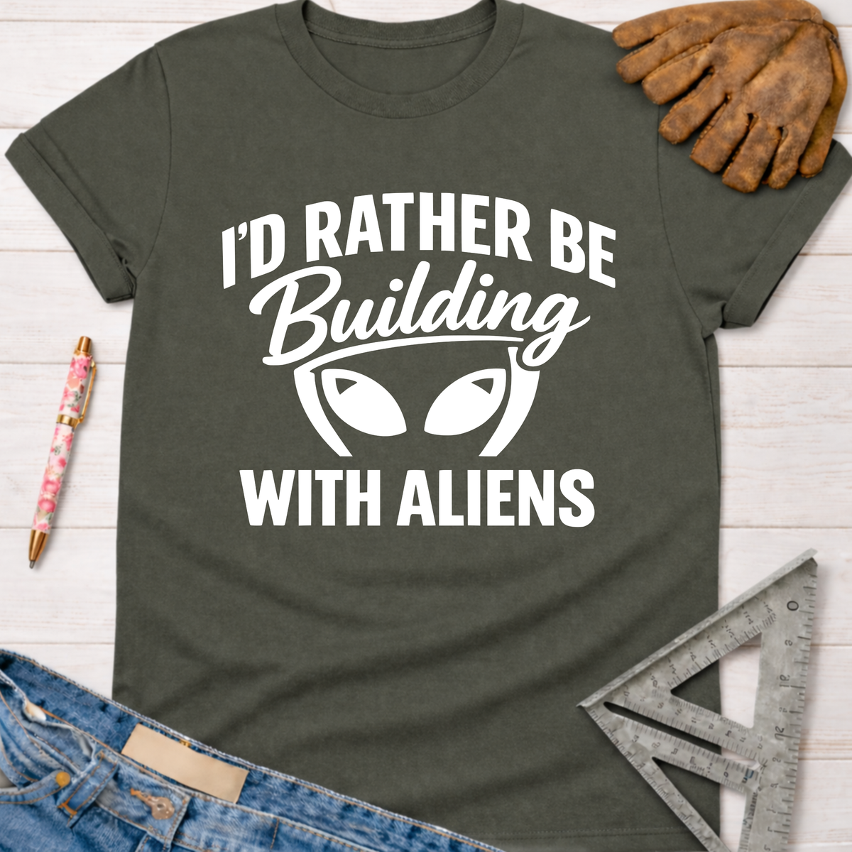 Women's funny woodworking graphic tee shirt for female woodworkers, makers, and DIY builders — Sawdust & Ponytails. Dark gray t-shirt with "I'd Rather Be Building With Aliens" white graphic.