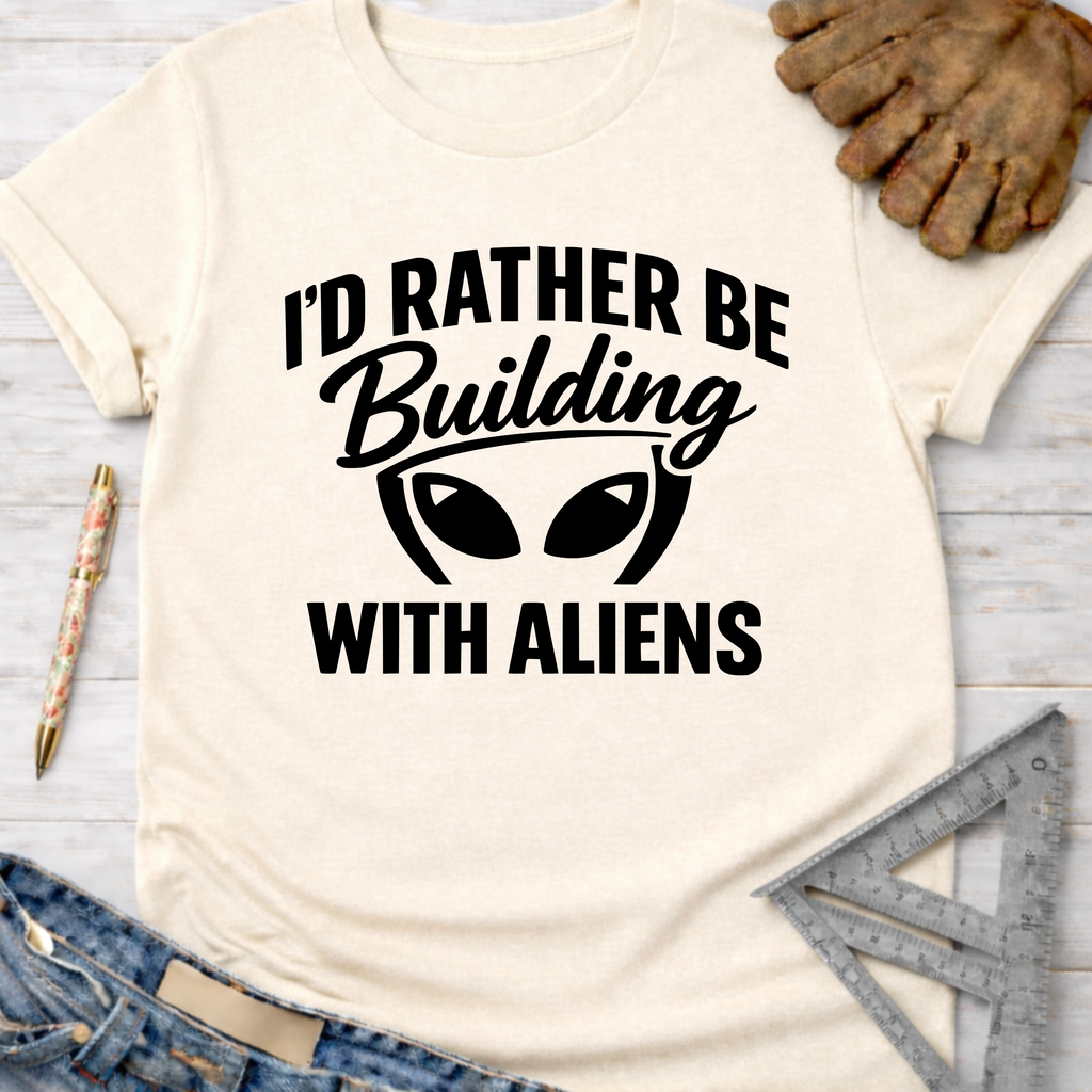 Women's funny woodworking graphic tee shirt for female woodworkers, makers, and DIY builders — Sawdust & Ponytails. Cream t-shirt with "I'd Rather Be Building With Aliens" graphic.