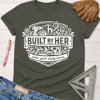 Women's funny woodworking graphic tee shirt for female woodworkers, makers, and DIY builders — Sawdust & Ponytails. Dark gray tee with "Built By Her" tools graphic.