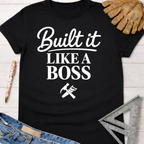 Women's funny woodworking graphic tee shirt for female woodworkers, makers, and DIY builders — Sawdust & Ponytails. Black cotton "Built It Like A Boss" graphic tee with hammer and saw icon.