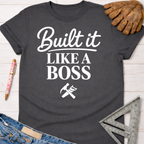 Women's funny woodworking graphic tee shirt for female woodworkers, makers, and DIY builders — Sawdust & Ponytails. Dark gray cotton t-shirt with "Built It Like A Boss" text and tools graphic.