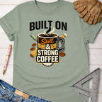 Sage green women's funny woodworking graphic tee with "Built On Skill & Strong Coffee" design, Sawdust & Ponytails.