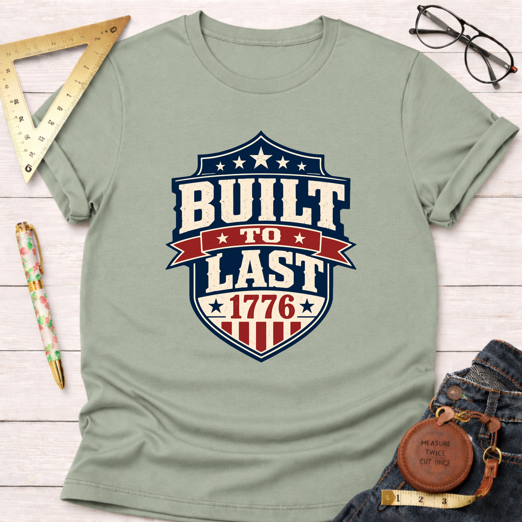 Sage green cotton t-shirt with a "Built To Last 1776" patriotic badge design.