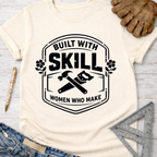 Women's funny woodworking graphic tee shirt for female woodworkers, makers, and DIY builders — Sawdust & Ponytails. Cream t-shirt with "Built With Skill Women Who Make" graphic, hammer, and saw.