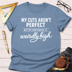 Women's funny woodworking graphic tee shirt for female woodworkers, makers, and DIY builders — Sawdust & Ponytails. Light blue cotton tee with "My Cuts Aren't Perfect But My Confidence Is Weirdly High" in white text.