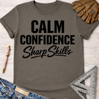 Women's funny woodworking graphic tee shirt for female woodworkers, makers, and DIY builders — Sawdust & Ponytails. Dark gray cotton tee with "Calm Confidence Sharp Skills" in black text.