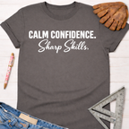 Charcoal gray women's "Calm Confidence. Sharp Skills." graphic tee, cotton blend, with rolled sleeves. Women's funny woodworking graphic tee shirt for female woodworkers, makers, and DIY builders — Sawdust & Ponytails