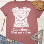 Women's funny woodworking graphic tee shirt for female woodworkers, makers, and DIY builders — Sawdust & Ponytails. Mauve t-shirt with a white graphic of a dog wearing safety goggles and "Calm down. She's got a plan." text.