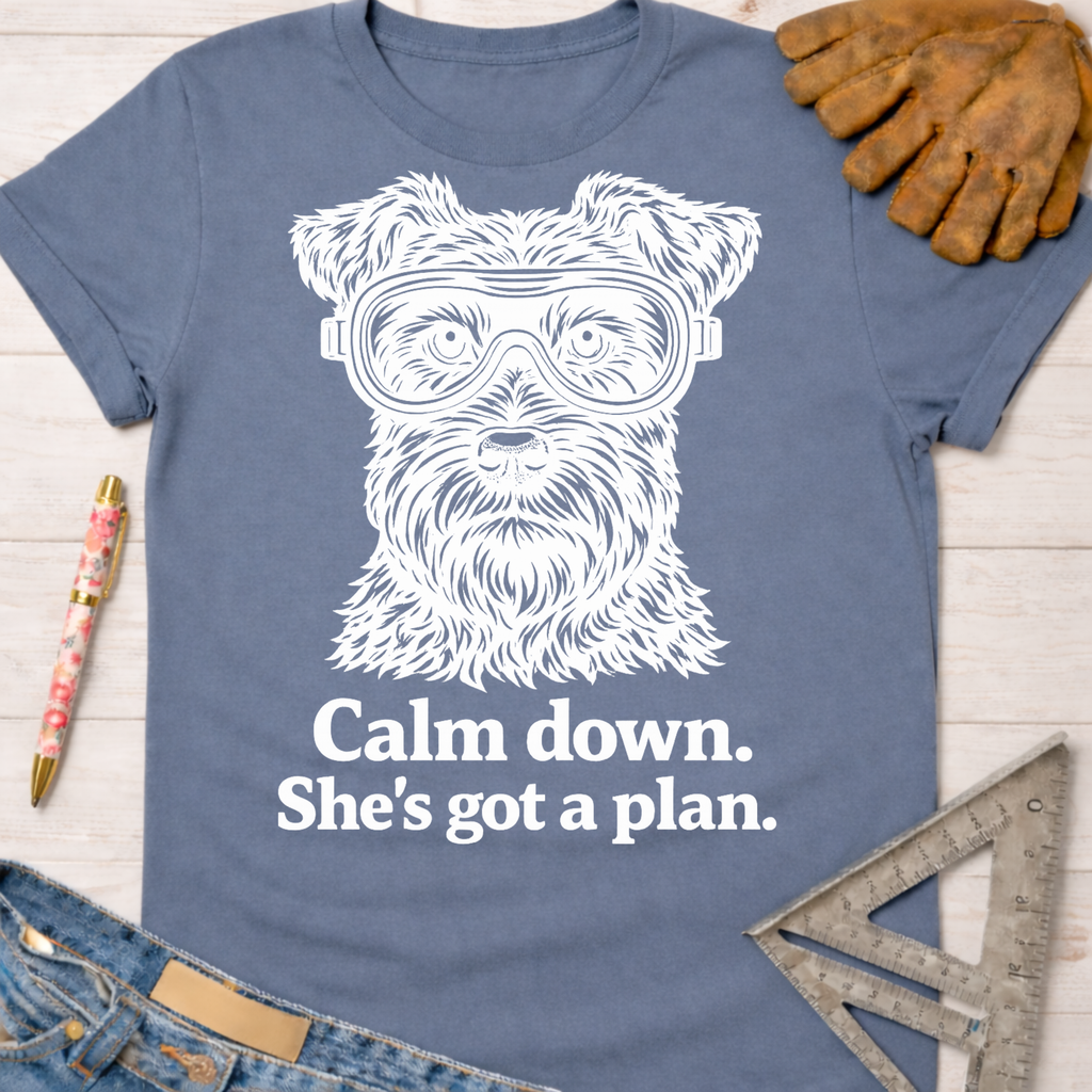Women's funny woodworking graphic tee shirt for female woodworkers, makers, and DIY builders — Sawdust & Ponytails. Blue cotton t-shirt with a white graphic of a dog wearing safety goggles and the text "Calm down. She's got a plan.