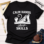 Black cotton t-shirt with "Calm Hands Sharp Skills" text and a hand plane graphic.