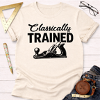 Women's funny woodworking graphic tee shirt for female woodworkers, makers, and DIY builders — Sawdust & Ponytails. Cream t-shirt with "Classically TRAINED" text and hand plane graphic.