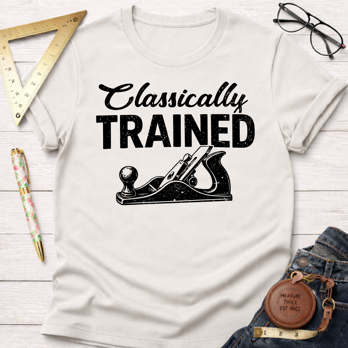 Women's funny woodworking graphic tee shirt for female woodworkers, makers, and DIY builders — Sawdust & Ponytails. Cream cotton tee with "Classically TRAINED" and a hand plane graphic.
