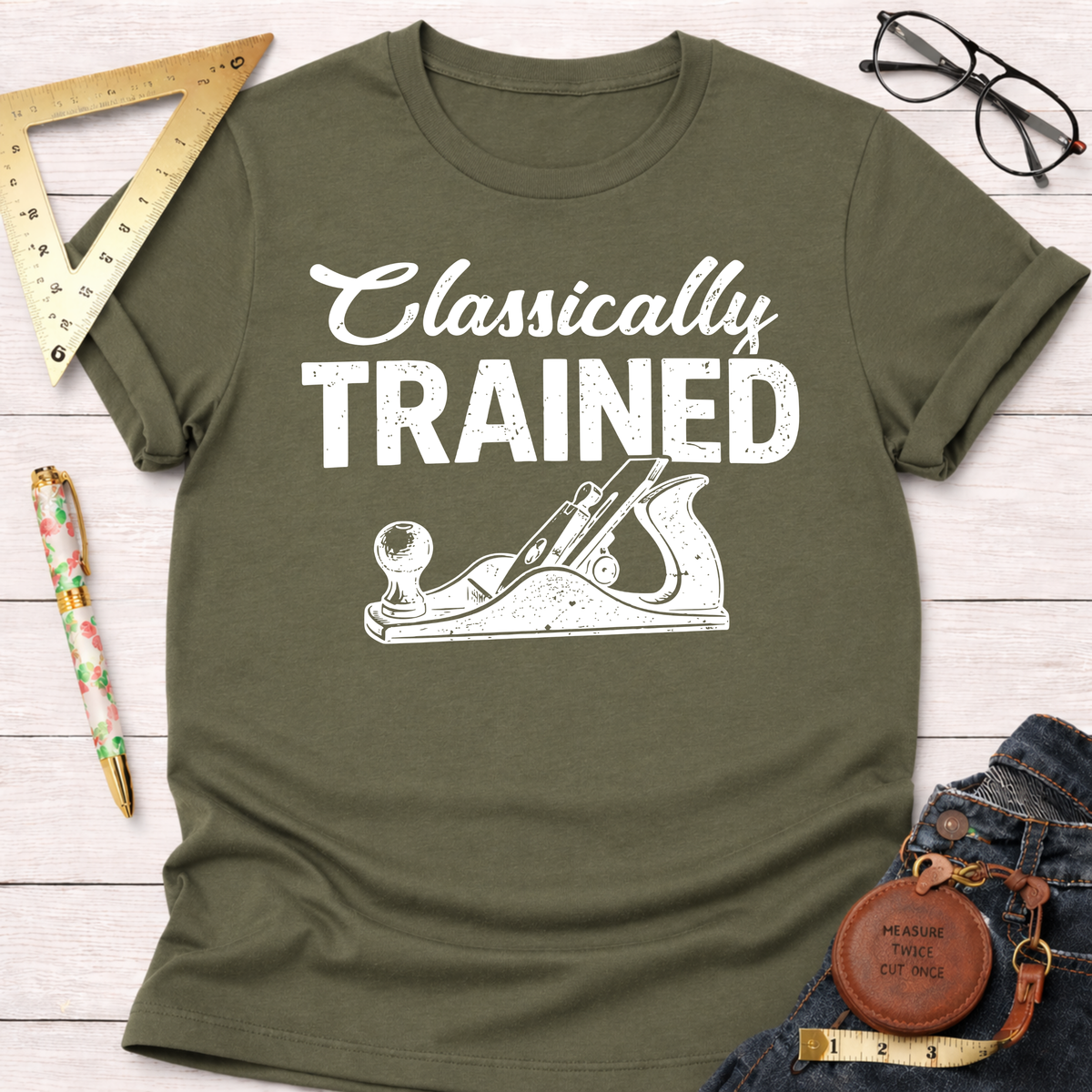 Women's funny woodworking graphic tee shirt for female woodworkers, makers, and DIY builders — Sawdust & Ponytails. Olive green cotton tee with "Classically Trained" and hand plane graphic.