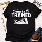 Women's funny woodworking graphic tee shirt for female woodworkers, makers, and DIY builders — Sawdust & Ponytails. Black cotton tee with "Classically TRAINED" text and a hand plane graphic.