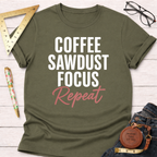 Olive green t-shirt with "COFFEE SAWDUST FOCUS" in white and "Repeat" in pink, styled with jeans and tools.