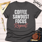 Dark gray cotton t-shirt with "COFFEE SAWDUST FOCUS Repeat" text in white and pink.