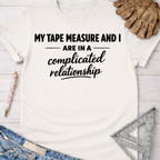 White cotton tee with "My Tape Measure And I Are In A Complicated Relationship" text. Women's funny woodworking graphic tee shirt for female woodworkers, makers, and DIY builders — Sawdust & Ponytails.