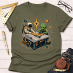 Olive green cotton t-shirt with a cosmic workshop graphic of an astronaut and alien woodworking at a table saw.